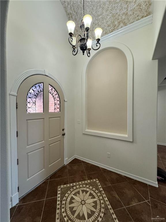 tiled foyer featuring a notable chandelier