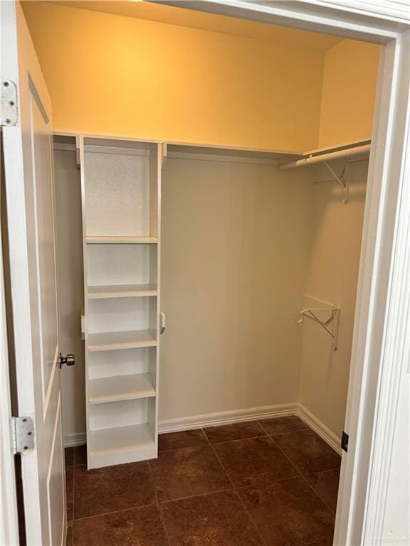 spacious closet featuring dark tile patterned flooring