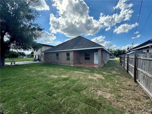 back of house with a yard and a patio area