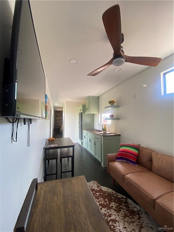 living room featuring ceiling fan and sink