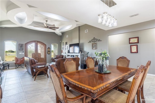 tiled dining area with ceiling fan with notable chandelier