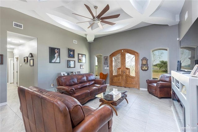 living room featuring light tile patterned floors, ceiling fan, and coffered ceiling