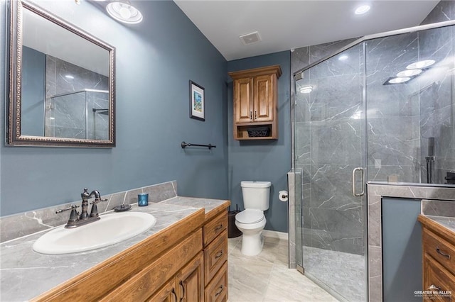 bathroom with vanity, toilet, and a shower with door