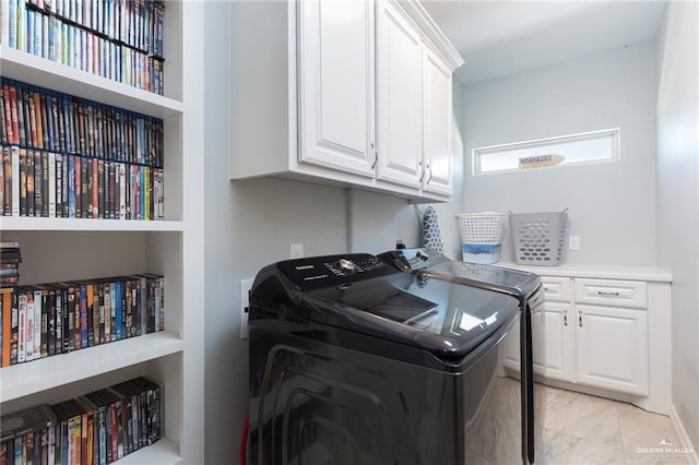 laundry room featuring washer and clothes dryer and cabinets