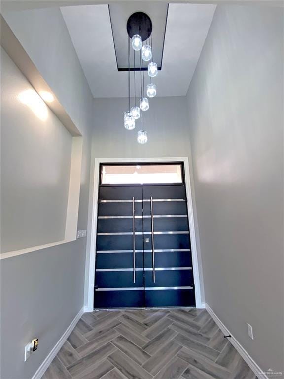 doorway with an inviting chandelier and parquet floors