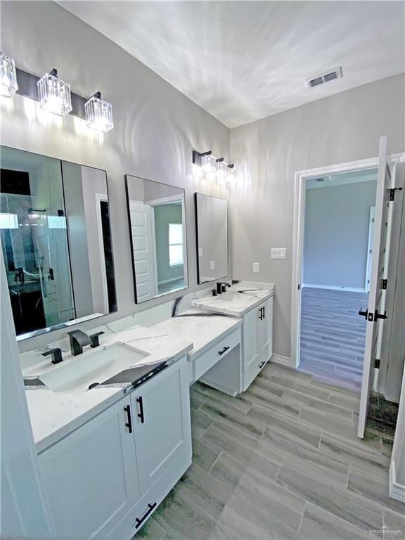 bathroom with hardwood / wood-style flooring, vanity, and a shower with door