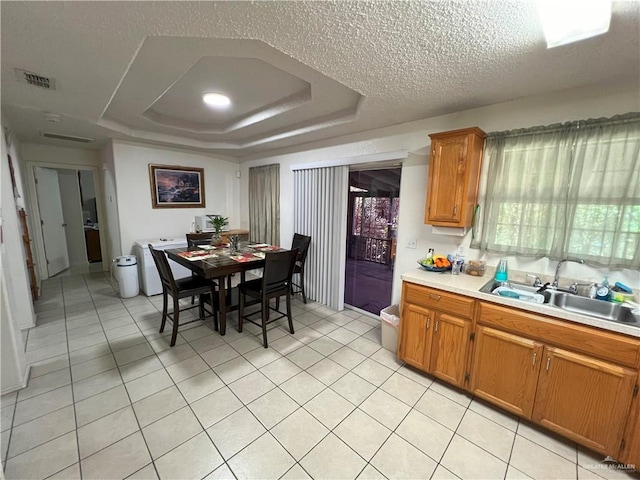 6502 S Galaxy Dr, Pharr, TX 78577 - kitchen featuring brown cabinetry, visible vents, a sink, a raised ceiling, and light countertops