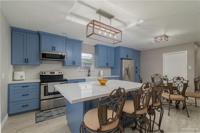 1008 Monterrey St, Edinburg, TX 78539 - kitchen with stainless steel appliances, blue cabinetry, light countertops, a breakfast bar area, and a kitchen island
