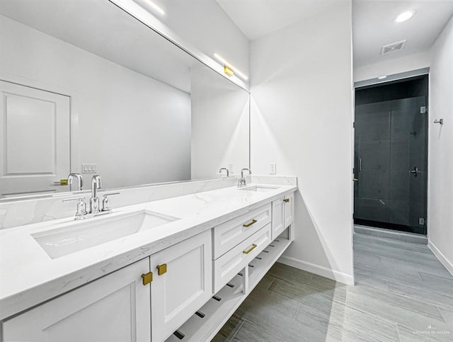 full bathroom with double vanity, a sink, visible vents, and baseboards