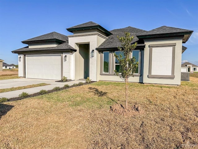 prairie-style home with driveway, a front lawn, and stucco siding