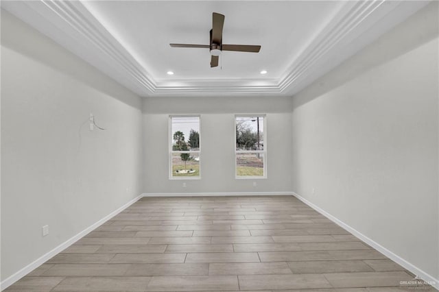 unfurnished room featuring light wood-type flooring, a raised ceiling, baseboards, and recessed lighting