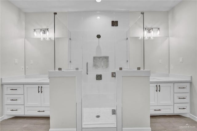 bathroom with a stall shower, wood finished floors, and vanity