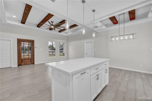 kitchen featuring white cabinetry, open floor plan, light countertops, a center island, and decorative light fixtures