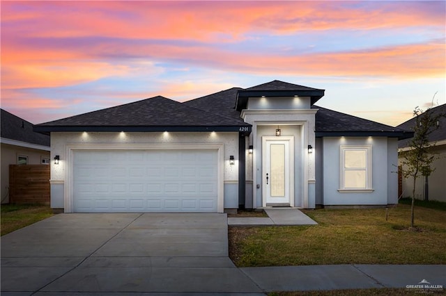 prairie-style house with a garage and a lawn