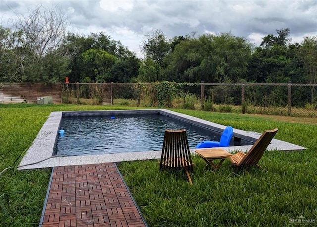 view of swimming pool with a yard