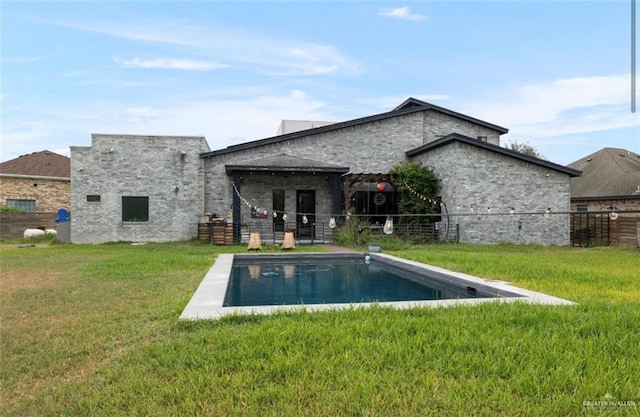 back of house featuring a fenced in pool and a yard