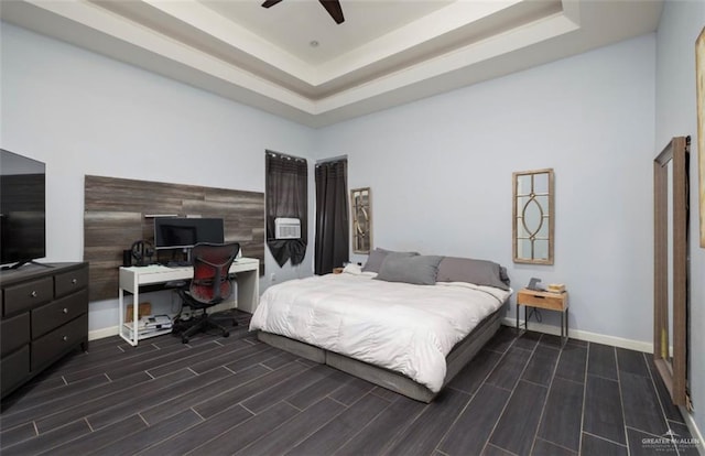 bedroom featuring a raised ceiling, ceiling fan, and dark hardwood / wood-style flooring