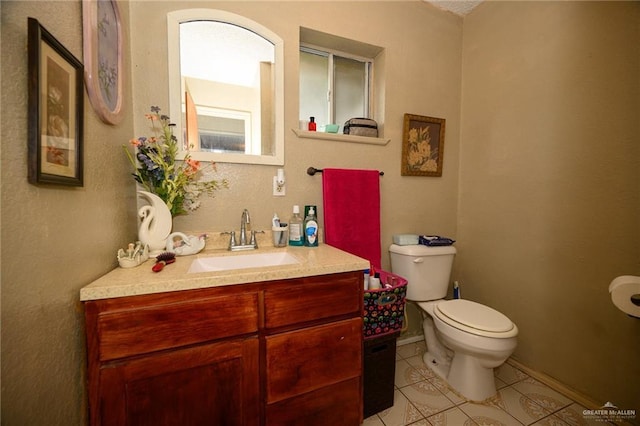 bathroom featuring tile patterned floors, toilet, vanity, and baseboards