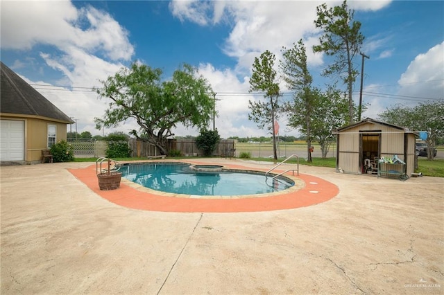 view of pool featuring an in ground hot tub, a patio, and a storage unit