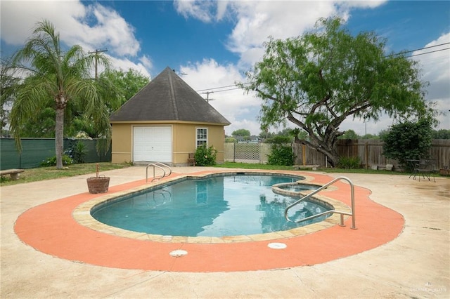 view of swimming pool featuring an outbuilding, a garage, and a patio