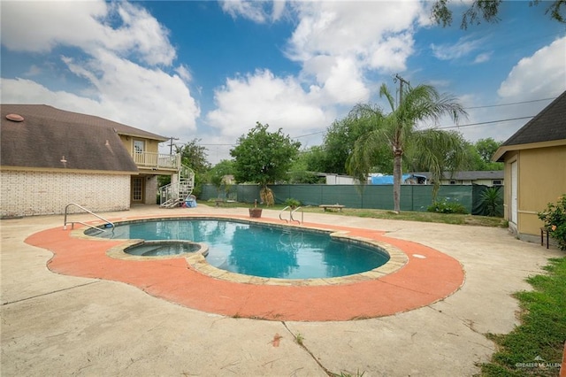 view of swimming pool featuring a patio area, stairway, fence, and a pool with connected hot tub