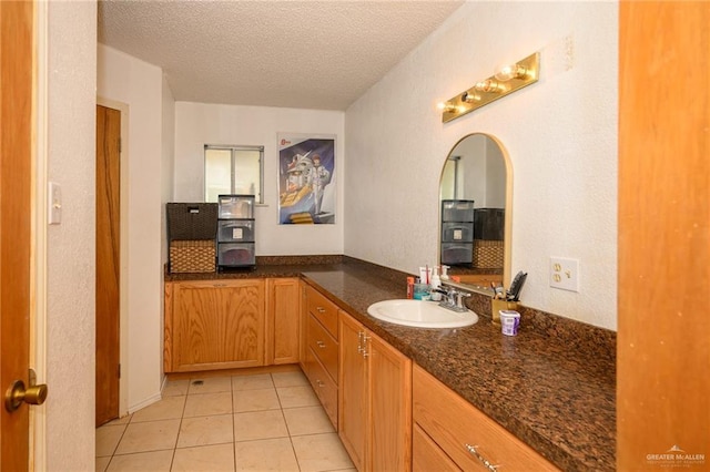 bathroom with vanity, tile patterned floors, and a textured ceiling