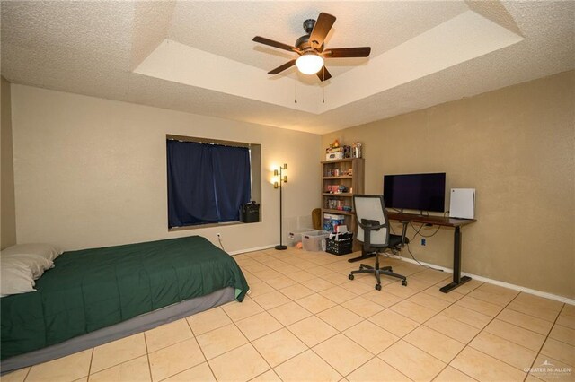 tiled bedroom featuring baseboards, a textured ceiling, and a tray ceiling