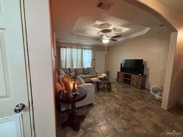 404 Flores St, Pharr, TX 78577 - living room with a tray ceiling, arched walkways, and ceiling fan