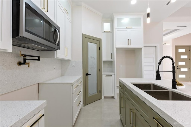 kitchen with pendant lighting, sink, decorative backsplash, and white cabinets