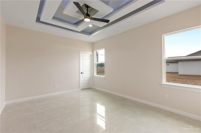 unfurnished room featuring ceiling fan and a tray ceiling