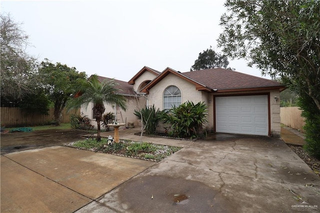 single story home with driveway, a garage, fence, and brick siding