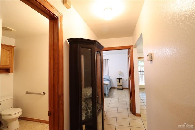 corridor with light tile patterned floors and baseboards