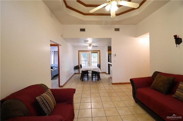 living area featuring a tray ceiling, french doors, visible vents, and light tile patterned floors