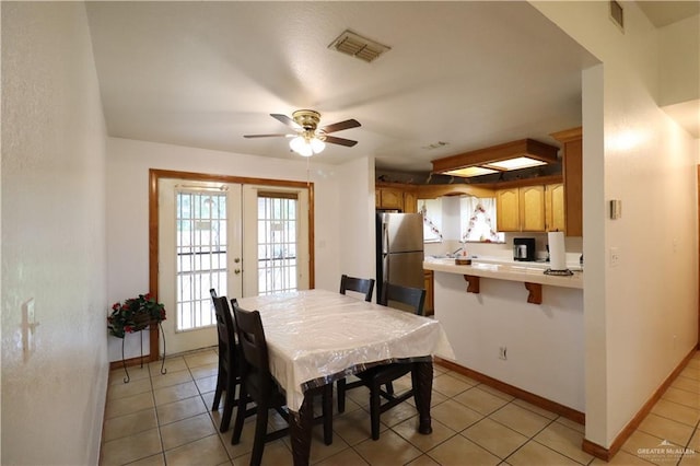 dining space featuring light tile patterned floors, baseboards, visible vents, and french doors