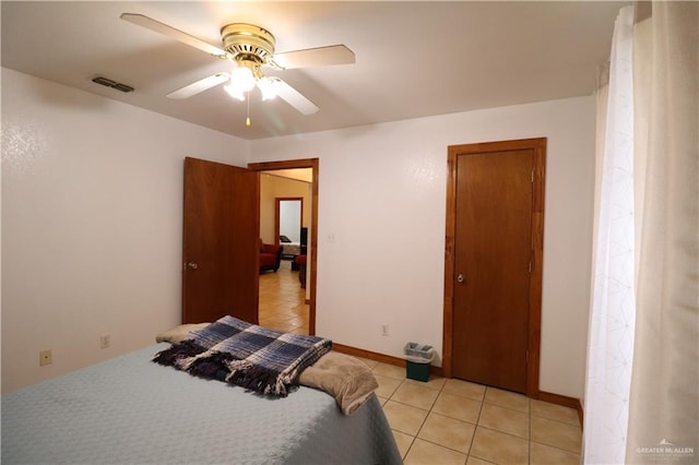 bedroom featuring ceiling fan, visible vents, baseboards, and light tile patterned flooring