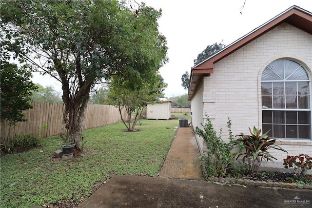 view of yard with central air condition unit, an outdoor structure, a storage shed, and fence