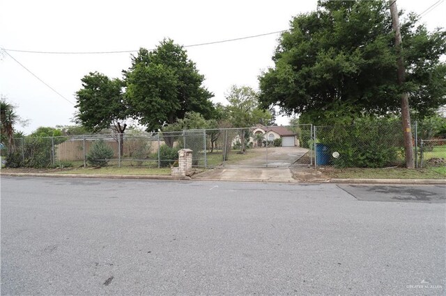 view of road featuring a gate and curbs