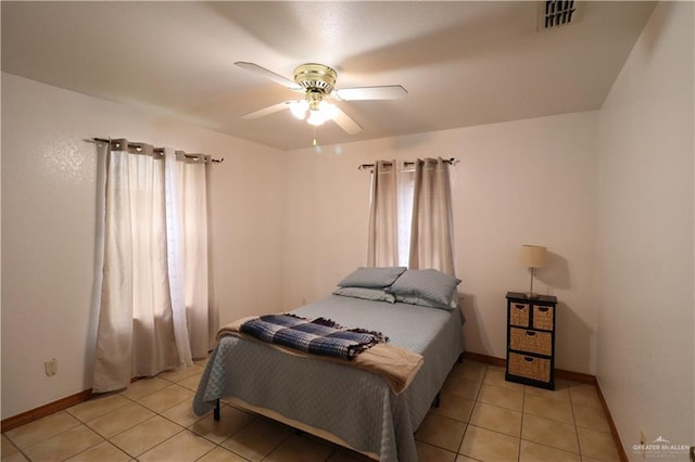 bedroom featuring light tile patterned floors, a ceiling fan, visible vents, and baseboards