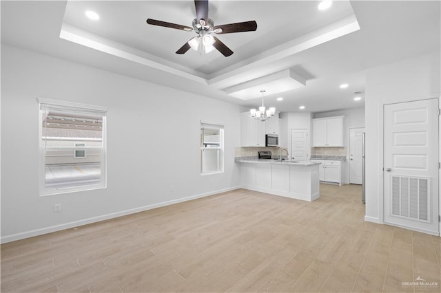 805 N Blair Ave, Edinburg, TX 78541 - kitchen with a tray ceiling, visible vents, open floor plan, white cabinets, and a peninsula