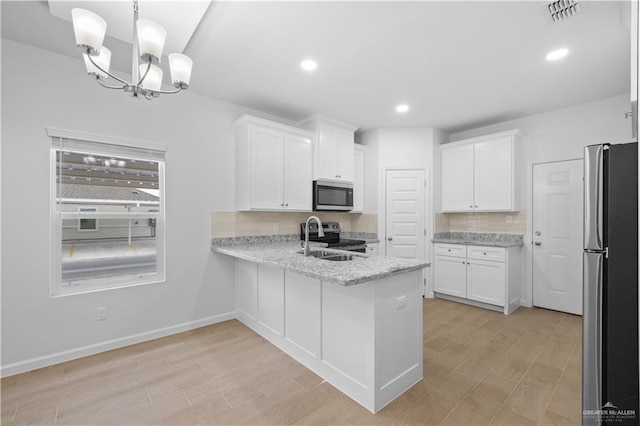 kitchen featuring a sink, visible vents, white cabinetry, hanging light fixtures, and appliances with stainless steel finishes