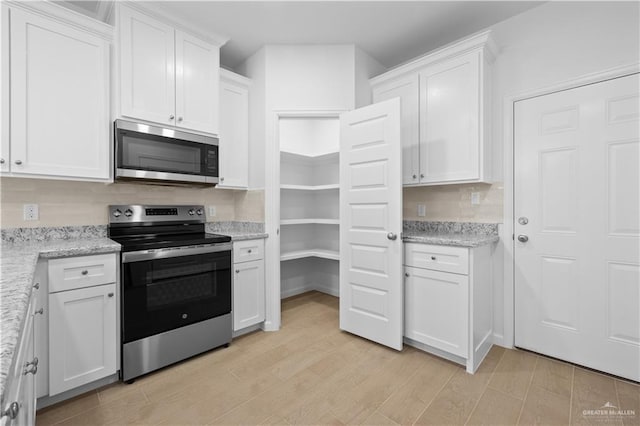 805 N Blair Ave, Edinburg, TX 78541 - kitchen with light stone countertops, light wood finished floors, white cabinetry, and stainless steel appliances