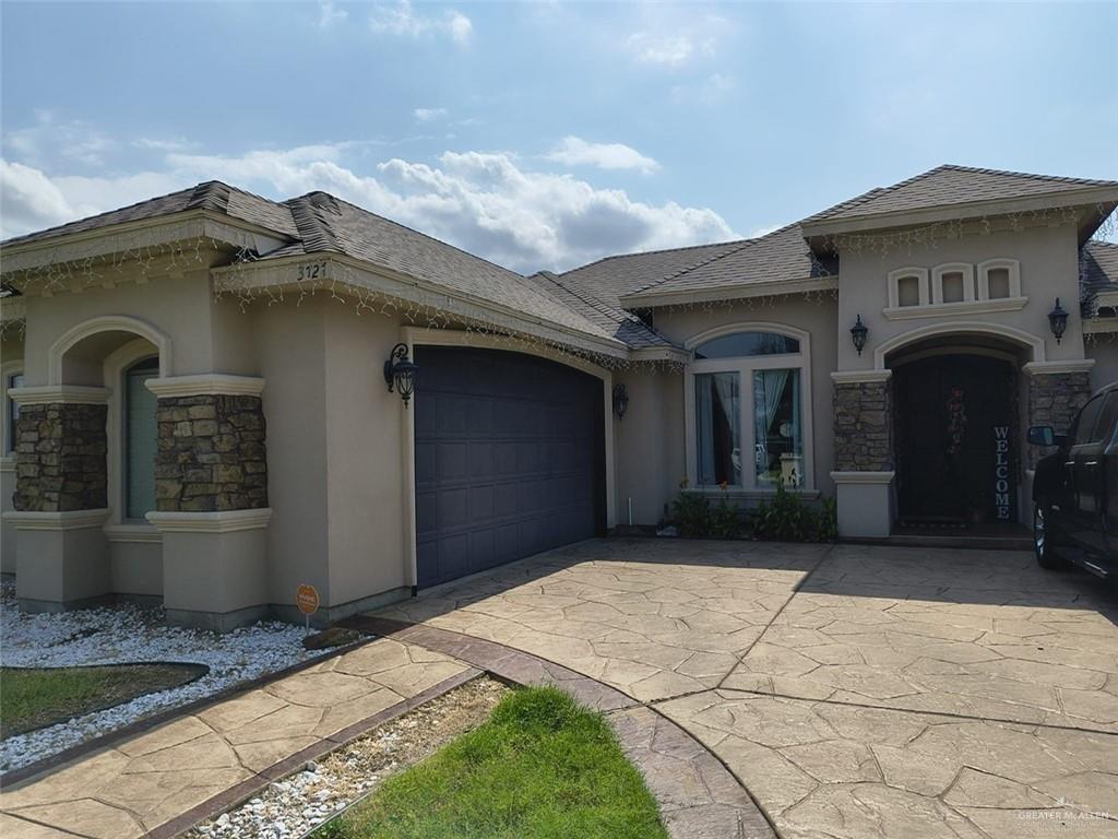 3727 Bianca St, Edinburg, TX 78539 - mediterranean / spanish-style home featuring driveway, stucco siding, stone siding, and an attached garage