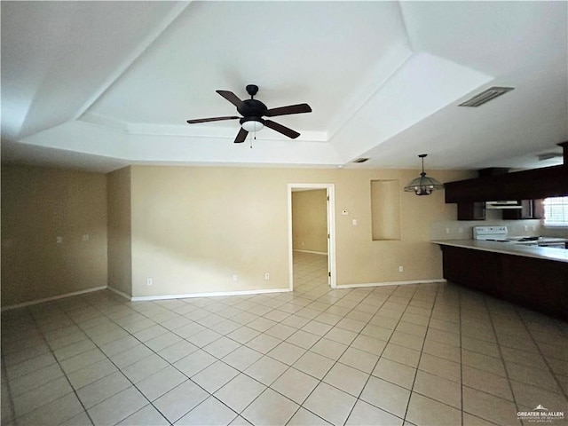 interior space featuring ceiling fan, light tile patterned flooring, and a tray ceiling