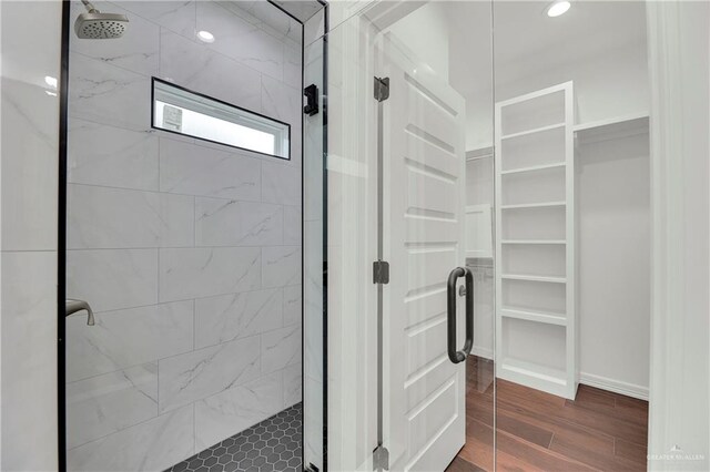 bathroom featuring wood-type flooring and tiled shower