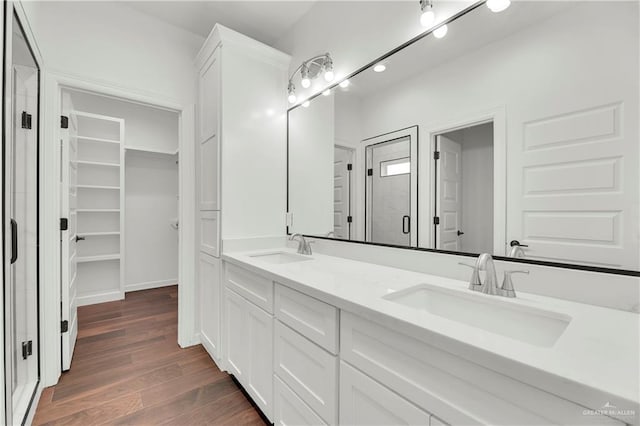 bathroom featuring hardwood / wood-style floors, vanity, and an enclosed shower