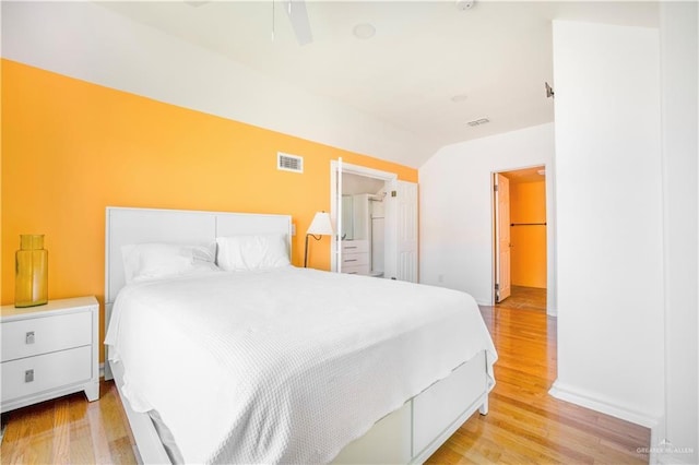 bedroom featuring ceiling fan, vaulted ceiling, and light hardwood / wood-style flooring