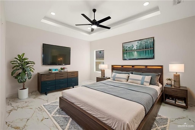 bedroom with ceiling fan and a raised ceiling