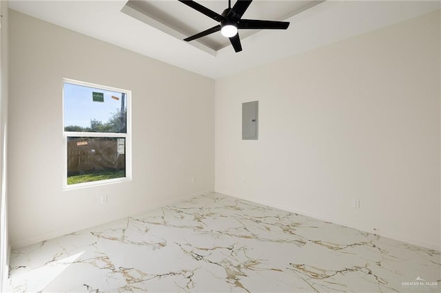 spare room with ceiling fan, a tray ceiling, and electric panel