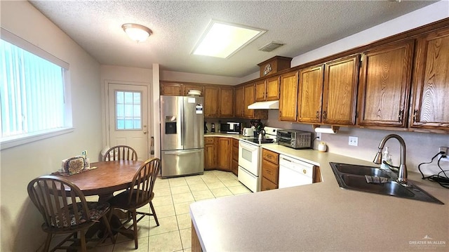 2434 Starling Cir E, Palmview, TX 78572 - kitchen featuring a textured ceiling, a sink, light tile patterned floors, under cabinet range hood, and white appliances