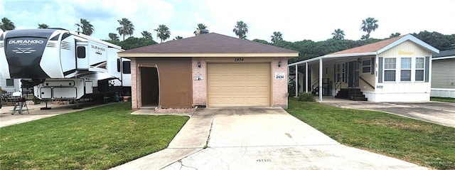 2434 Starling Cir E, Palmview, TX 78572 - view of front of home featuring concrete driveway, brick siding, a front yard, and a garage